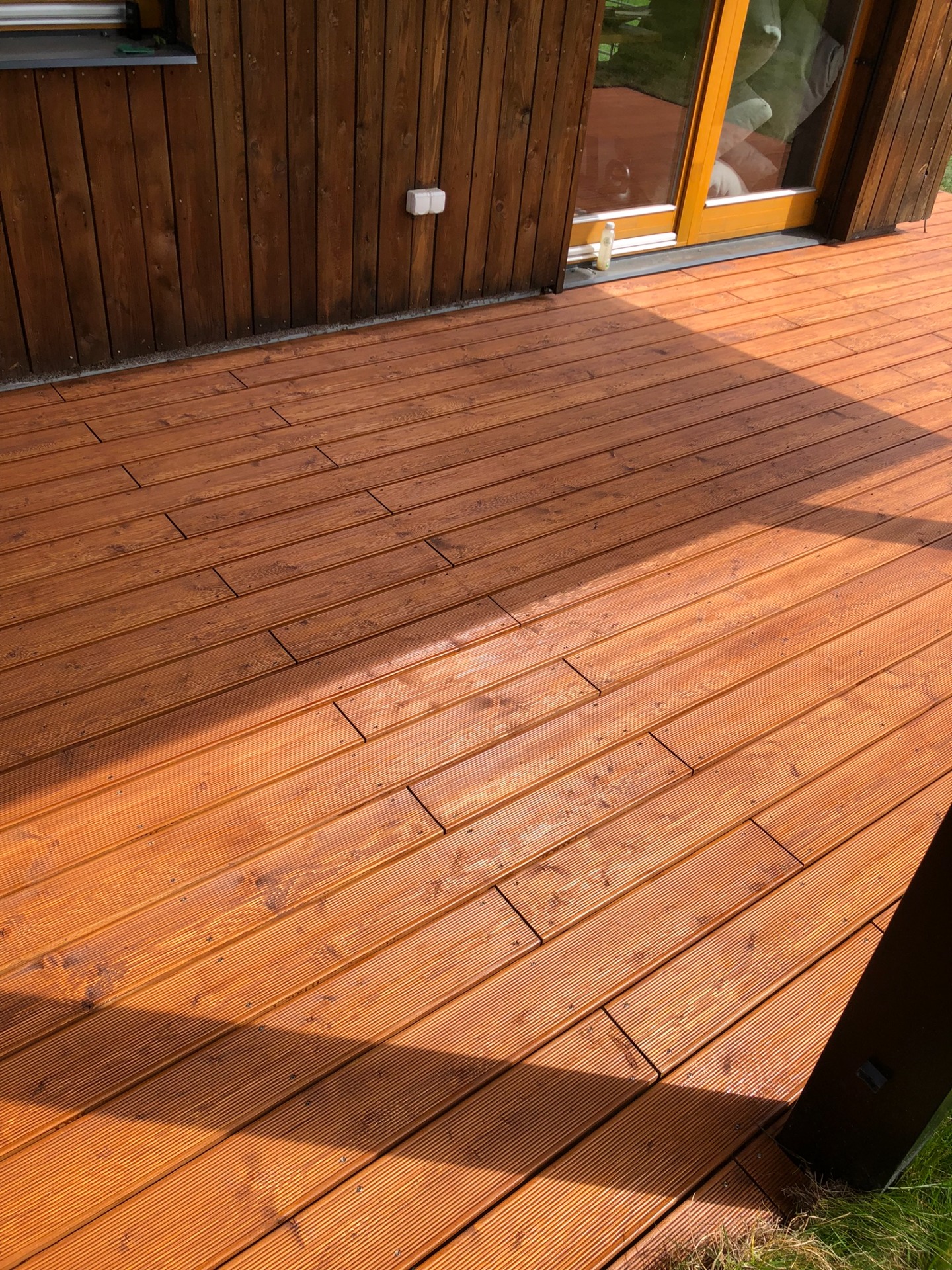 Terasa ze sibiřského modřínu s přiznaným kotvením a pigment v barvě ořechu.